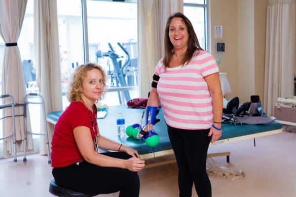Therapist assists a resident during a rehabilitation activity