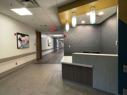 Bright lobby area with a reception desk and hallway