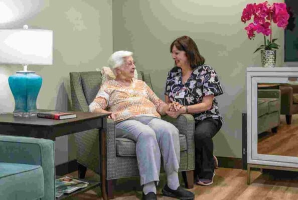 Staff member engaging with a resident in a cozy common area