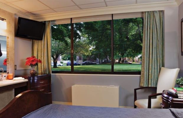 View of a resident room with a window and greenery outside