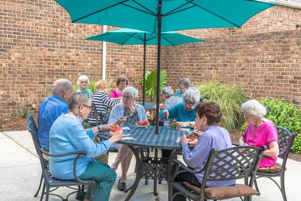 Residents enjoying a meal outside under umbrellas