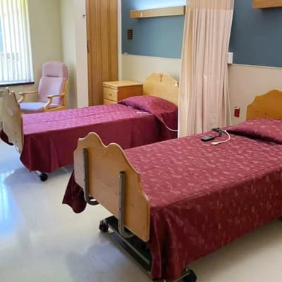 Two unoccupied beds in a shared resident room