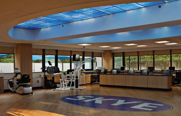 Bright fitness area with equipment and large windows