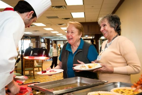 Residents enjoying a meal service with a chef