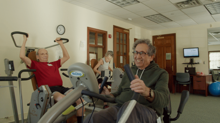 Residents participating in a fitness activity in a common room