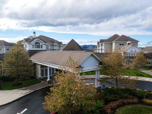 Exterior view of a senior living facility with autumn trees