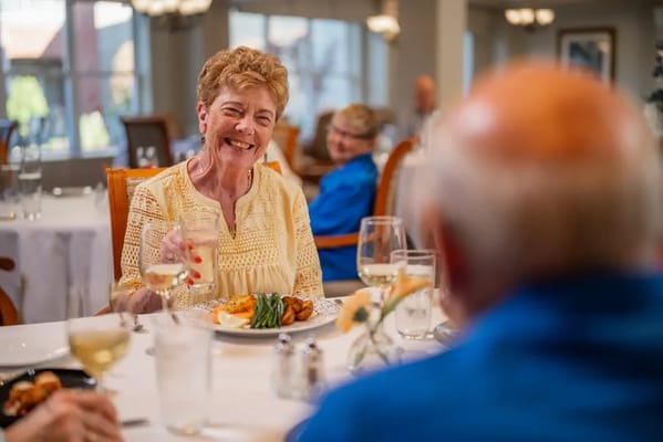 Residents enjoying dinner in a bright dining room