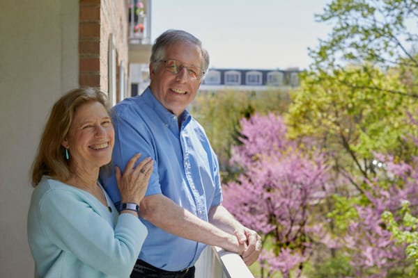Two residents enjoying a sunny day on a balcony
