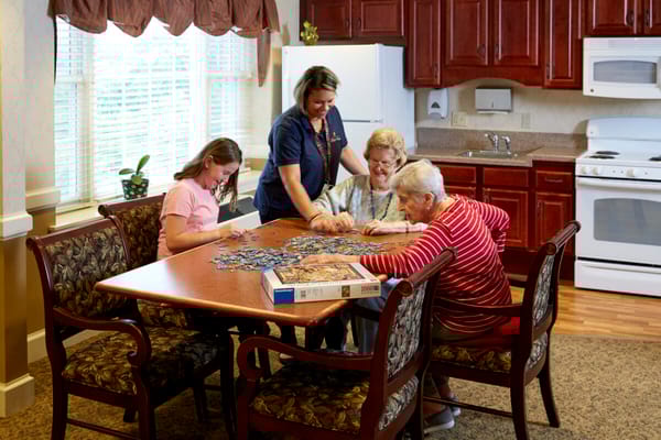 Residents and staff engaged in a puzzle activity