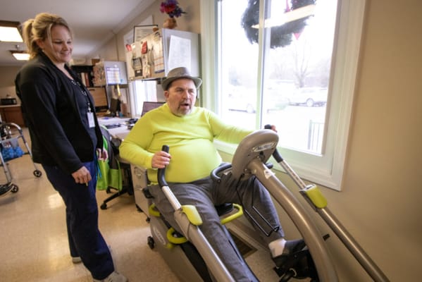 Resident engaging in exercise with staff assistance