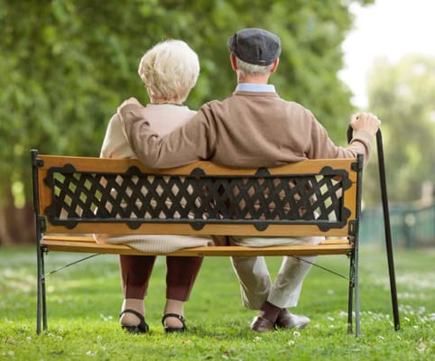 Couple sitting on a bench in a garden