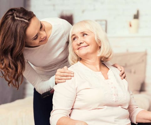 Caregiver and resident sharing a joyful moment indoors