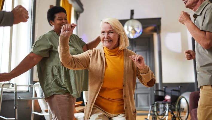 Residents dancing joyfully in an activity room