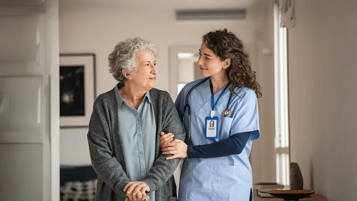 A caregiver assisting a resident in a hallway