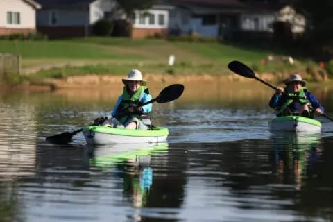 Two residents kayaking on a calm lake