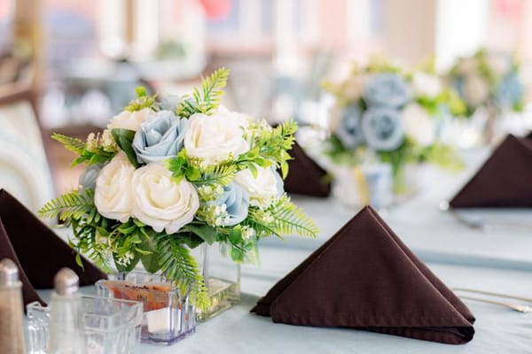 Beautifully set dining table with flowers and napkins
