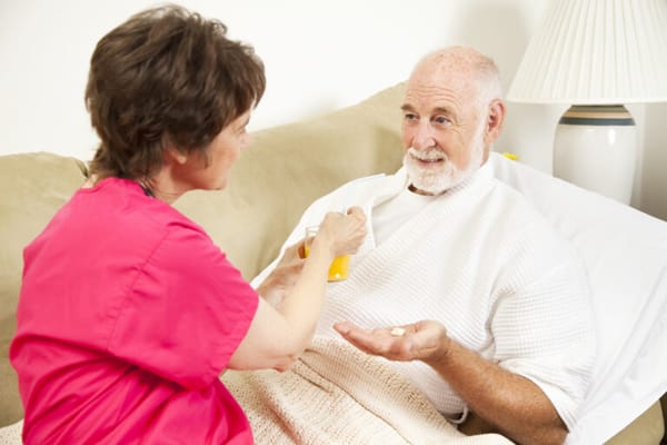 A caregiver assisting a senior with medication
