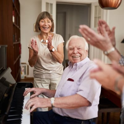 Residents enjoying a piano performance in a common area