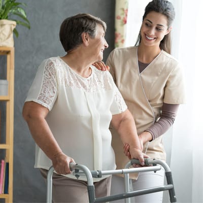 A caregiver assisting a resident with a walker
