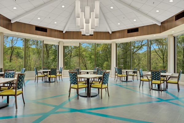 Bright dining room with large windows overlooking trees