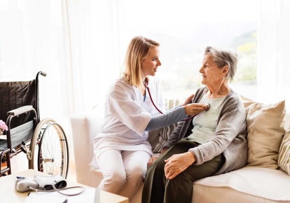 A caregiver assisting a senior resident indoors