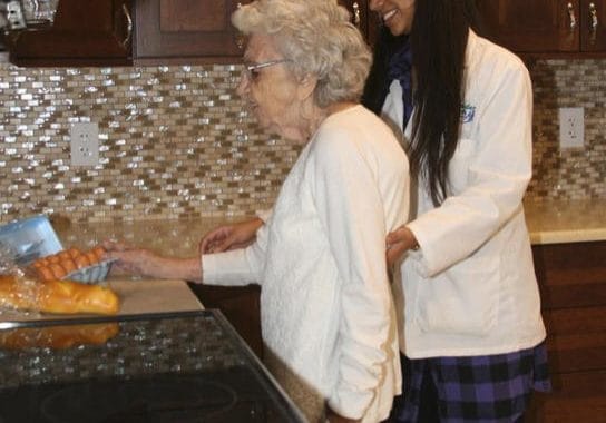 Staff helping a resident in the kitchen