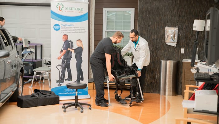 Staff assisting resident with mobility equipment in a common area