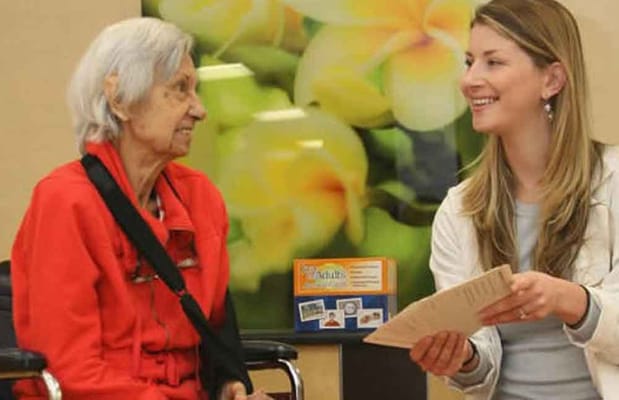 A staff member engaging with a resident in an activity room