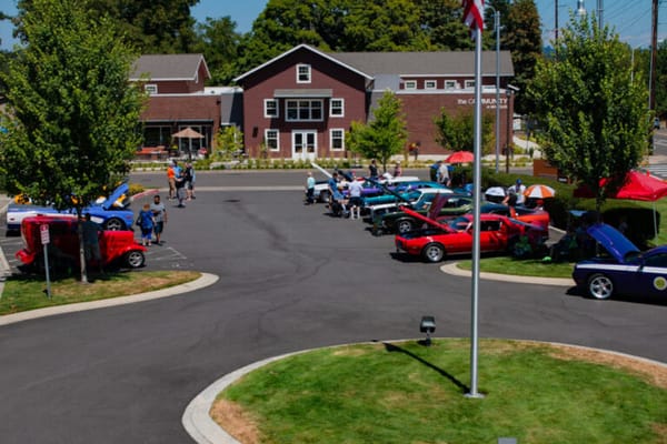 Outdoor car show with community members and classic cars