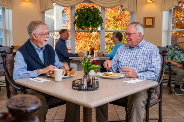 Two residents sharing a meal at a dining table