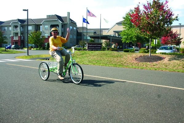 A resident riding a tricycle in front of the facility