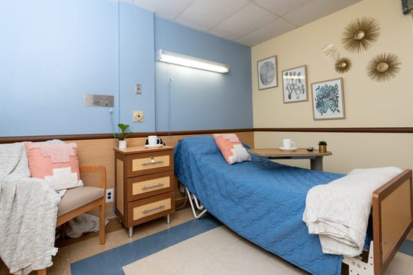 A private resident room with a blue bedspread and decor