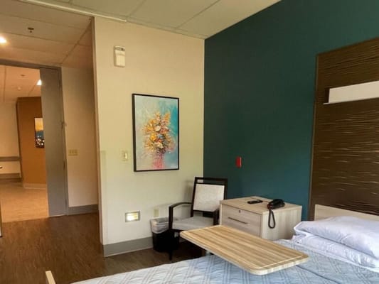 Cozy interior of a resident room with a bed and artwork