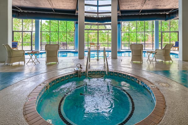 Indoor pool area with spa and seating