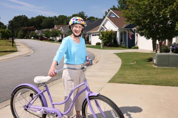 Senior woman smiling while riding a bicycle