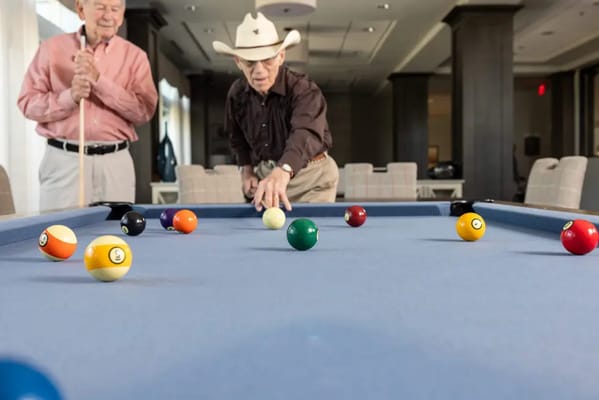 Residents playing billiards in a common area