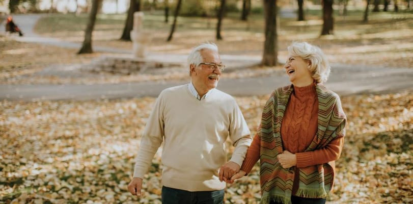 Seniors walking together in a park during autumn