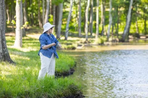 A resident fishing by the water in a natural setting
