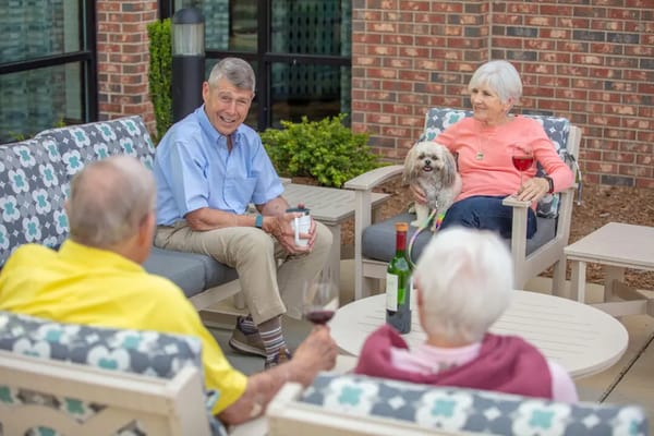 Residents enjoying a sunny outdoor gathering with a dog