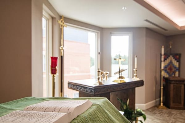 Interior chapel space with a Bible and altar.