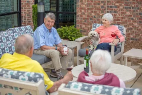 Residents and staff enjoying time outdoors with a dog