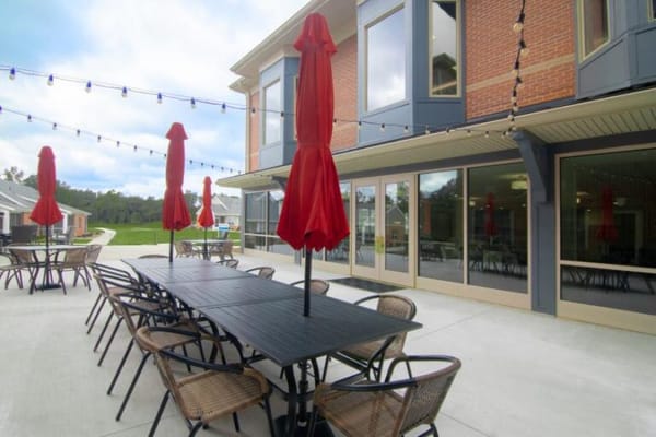 Outdoor patio with red umbrellas and tables