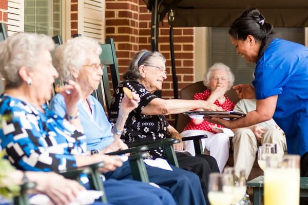 Residents enjoying snacks on a sunny patio