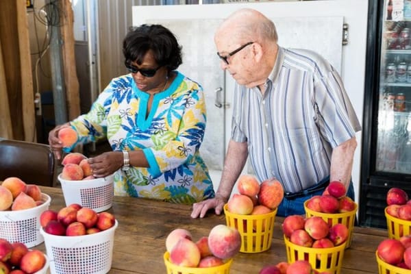 Residents and staff sorting fresh peaches together