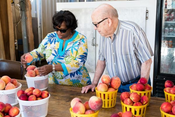 Residents and staff sorting fresh peaches together