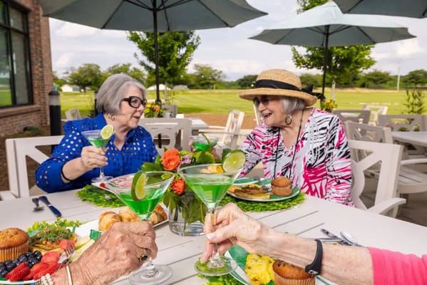 Residents enjoying drinks at an outdoor dining table