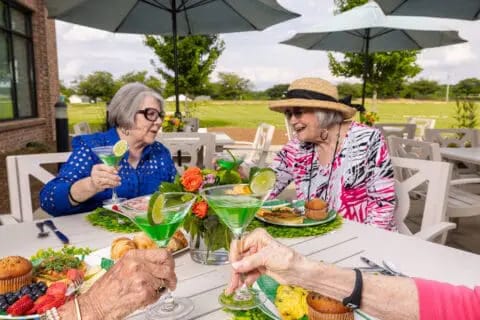 Residents enjoying refreshments outdoors at a picnic table
