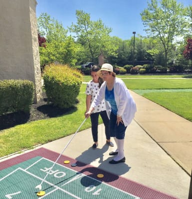 Residents participating in outdoor shuffleboard activity