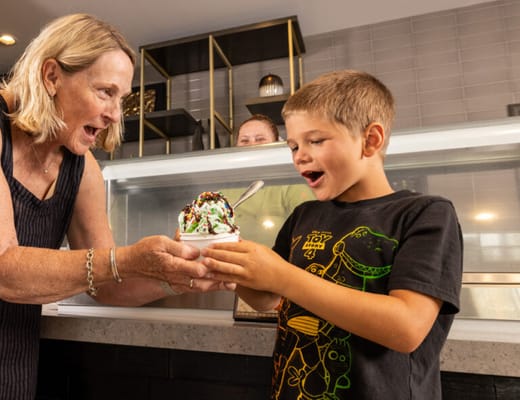 A resident serving ice cream to a young boy