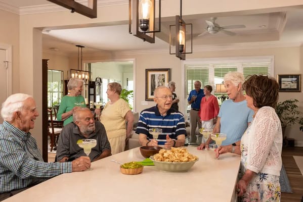 Residents enjoying drinks and conversation in a warm social space